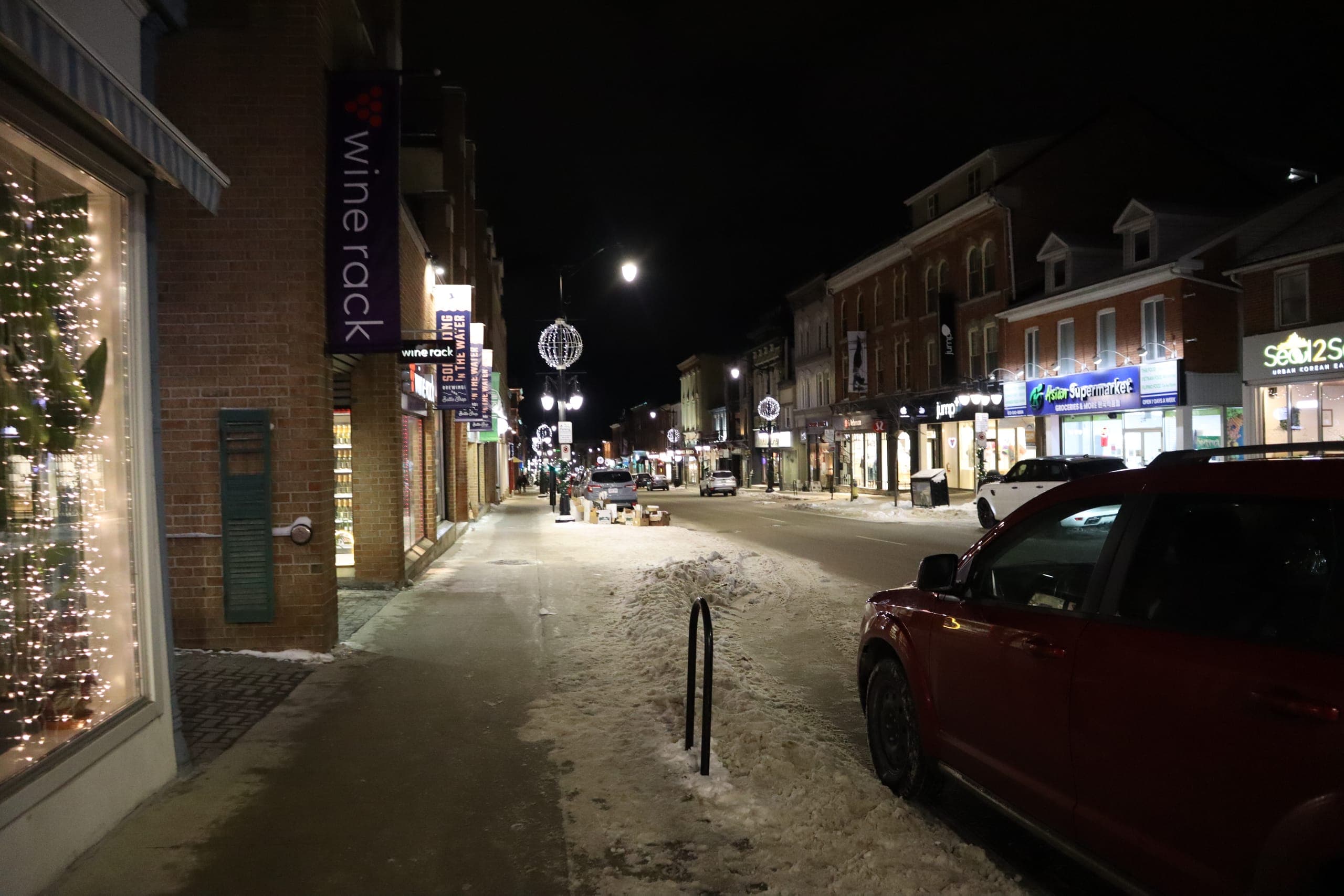 Princess Street downtown at night in winter, shopfronts lit